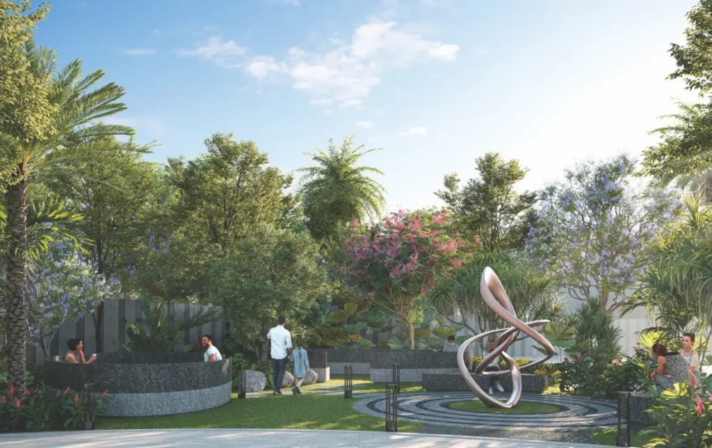 Floral garden at Roots Courtyard 2 featuring artistic sculpture, lush greenery, and community seating