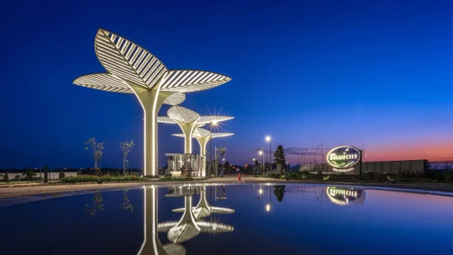 Entrance gateway of AIPL Lake City Sector 103 at night with iconic leaf-shaped lighting structures