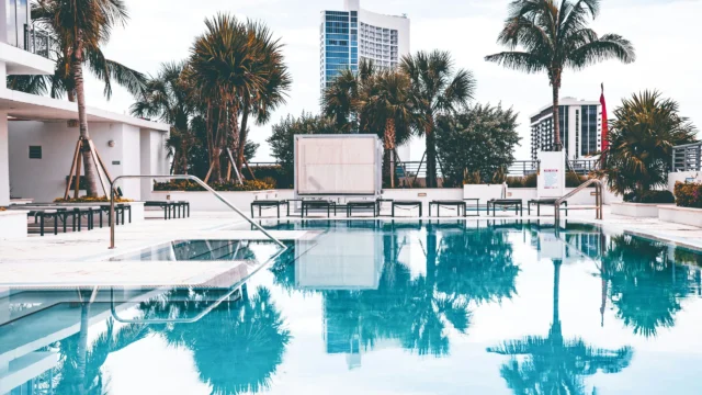 SS Camasa luxury poolside with palm trees and city backdrop in Sector 90 Gurugram
